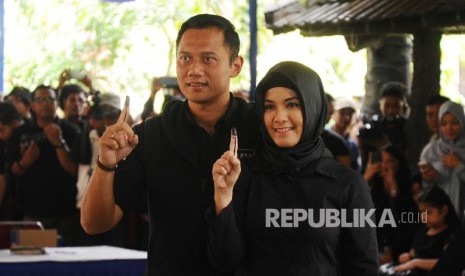 Cagub nomor urut satu Agus Harimurti Yudhoyono (kiri) bersama istri Anissa Pohan menunjukkan jari usai melakukan pencoblosan Pemilihan Kepala daerah DKI Jakarta di TPS 06 Rawa Barat, Kebayoran Baru, Jakarta Selatan, Rabu (15\2). 