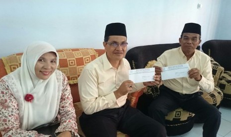  Calon bupati Bima Abdul Khayir (tengah) didampingi istri Roswati Ibrahim (kiri) dan calon wakil bupati Bima (kanan) saat menyerahkan perbaikan berkas ke KPU Bima, Rabu (5/8).