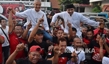 Calon gubernur dan calon wakil gubernur Jawa Tengah Ganjar Pranowo (kiri) dan Taj Yasin dipanggul para pendukung merayakan keunggulan dalam hitung cepat Pilkada Jateng 2018 versi sejumlah lembaga survei di Kantor DPD PDI Perjuangan Jateng, Semarang, Jawa Tengah, Rabu (27/6). 