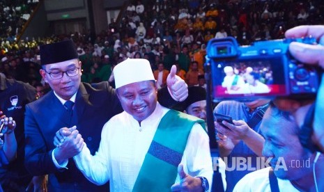 Calon Gubernur dan Wakil Gubernur Jabar Ridwan Kamil dan UU berfoto bersama dengan simpatisan yang hadir pada Rapat Akbar Keluarga Rindu Jabar Juara, di Gedung Sabuga, Kota Bandung, Kamis (8/2) malam.