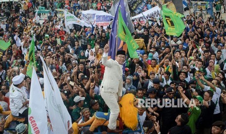  Calon Gubernur dan Wakil Gubernur Jawa Barat nomor urut satu Ridwan Kamil (tengah) dan Uu Ruzhanul Ulum (kiri) diarak menggunakan sisingaan saat kampanye akbar pasangan calon Rindu di Lapangan Tegalega, Bandung, Jawa Barat, Sabtu (23/6). 