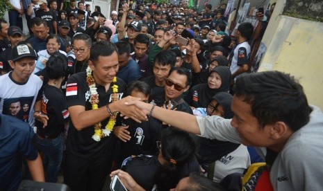 Calon Gubernur DKI Jakarta Agus Harimurti Yudhoyono (kiri) berjabat tangan dengan pendukungnya saat berkampanye di Cilandak Barat, Jakarta, Minggu (8/1). 