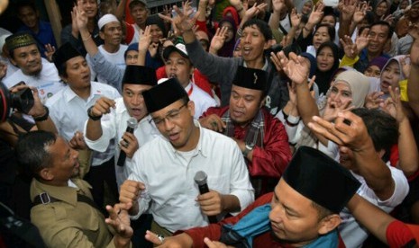 Calon gubernur DKI Jakarta Anies Baswedan melakukan flashmob diiringi lagu 'Ganteng Pake Peci' bersama warga sekitar Jalan Kelingkit Kampung Sawah saat sosialisasi janji kerja di kawasan, Menteng Dalam, Tebet, Jakarta Selatan (3/2).