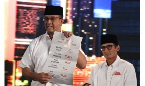 Calon Gubernur DKI Jakarta Anies Baswedan menunjukkan kertas yang berisi catatan mengenai buruknya pencapaian birokrasi di Jakarta dalam debat kandidat kedua di Jakarta, Jumat (27/1).