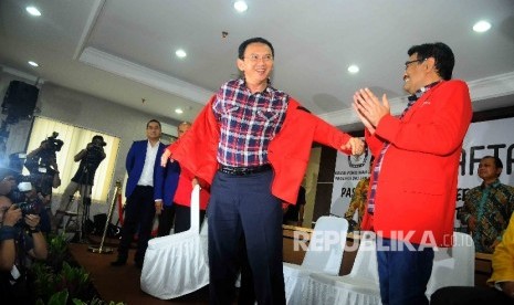 Calon gubernur DKI Jakarta Basuki Tjahaja Purnama mengenakan jaket pertai secara simbolis didampingi wakil gubernur Djarot Saifut Hidayat saat mendaftar sebagai Pasangan calon gubernur dan wakil gubernur DKI Jakarta periode 2017-2022 di Gedung KPUD DKI Jak