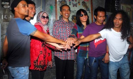 Calon Gubernur DKI Jakarta Joko Widodo (tengah) saat mengunjungi markas Slank didampingi manajer Slank, Bunda Iffet, Bunda Ifet (tiga kiri) serta personil grup band Slank di Jl Potlot, Duren Tiga, Jakarta Selatan, Senin (16/4). Kedatangan Jokowi tersebut u