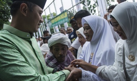 Calon Gubernur DKI Jakarta nomer urut satu Agus Harimurti Yudhoyono (kiri) menyalami warga saat menghadiri Tablig Akbar dan Istigasah di Lapangan Blok S, Jakarta, Kamis (9/2). 