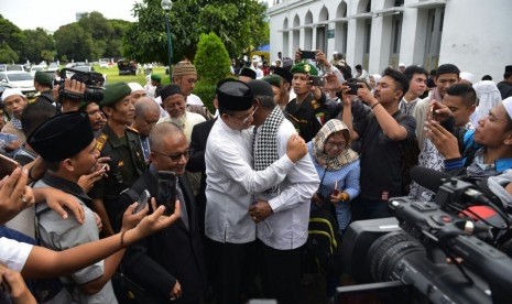 Calon gubernur DKI Jakarta nomor urut 3, Anies Baswedan, memeluk guru SMPnya, Sudjono Ragil Santoso, saat mereka bertemu di Tabligh Akbar Politik Indonesia Ketujuh (TAPI-7) di Masjid Al Azhar, Jakarta, Ahad (15/1).