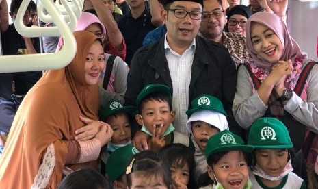 Calon gubernur Jabar nomor urut 1 Ridwan Kamil berswafoto dengan warga di dalam gerbong KRL Bekasi, Selasa (27/2).