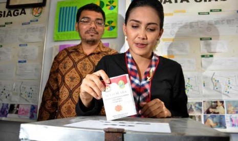  Calon Gubernur Jawa Barat Rieke Diah Pitaloka di dampingi oleh suaminya usai menggunakan hak pilihnya di TPS 20 Kukusan, Beji, Depok, Jawa Barat, Ahad (24/2). 