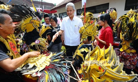 Calon Gubernur Jawa Tengah nomor urut satu Ganjar Pranowo (tengah) menyapa pemain kesenian drum blek saat kampanye di Salatiga, Jawa Tengah, Kamis (12/4).