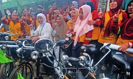 Calon Gubernur Jawa Timur, Khofifah Indar Parawansa (tengah) melakukan swafoto dengan komunitas sepeda onthel di Desa Plumbon Gambang, Gudo, Jombang, Jawa Timur, Kamis (22/3).