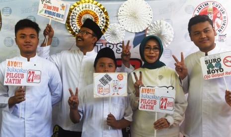 Calon Gubernur Jawa Timur Saifullah Yusuf (kedua kiri) bersama istri Fatma Saifullah Yusuf (kedua kanan) dan anak-anak berpose dengan atribut yang disediakan di tempat pemungutan suara (TPS) 3 di Gayungan, Surabaya, Jawa Timur, Rabu (27/6). 