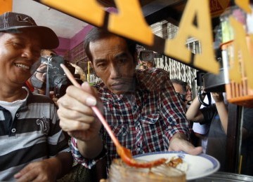 Calon Gubernur Joko Widodo makan siomay di Jalan Gajah Mada-Hayam Wuruk, Ahad (1/3). (Republika/Adhi Wicaksono)