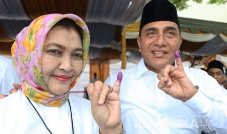 Calon Gubernur Sumatera Utara nomor urut satu Edy Rahmayadi (kanan) didampingi istri Nawal Lubis, menunjukkan jari kelingking usai memberikan hak suara pada Pilgub Sumut, di TPS 15, Lingkungan VII Pangkalan Masyhur, Medan Johor, Medan, Sumatera Utara, Rabu (27/6). 