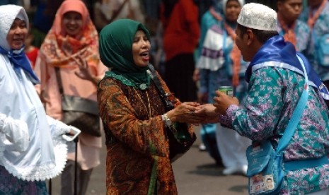 Calon haji bersalaman dengan kerabatnya sebelum berangkat ke Tanah Suci Makkah.