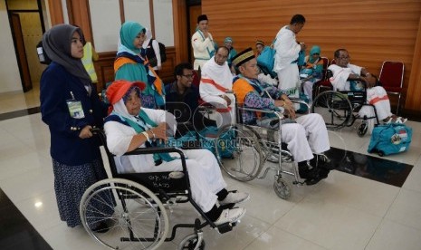 Calon Haji difabel berjalan dengan bantun petugas saat berada di Asrama Haji Pondok Gede, Jakarta, Selasa (8/9).   (Republika/Yasin Habibi)