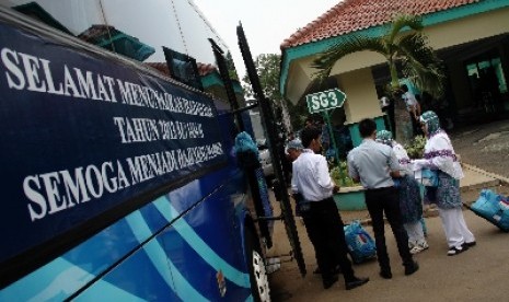 Calon jamaah haji kelompok terbang (kloter) 13 asal DKI Jakarta berjalan menuju bus saat pemberangkatan di Asrama Haji Pondok Gede, Jakarta,