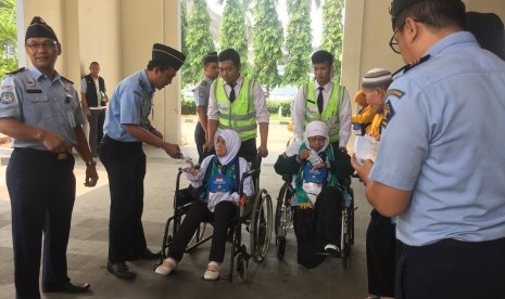 Calon jamaah haji kloter 20 asal Serang, Banten, Eti Suhaeti (64 tahun) (kanan) saat akan bertolak ke bandara di Asrama Haji Pondok Gede, Kamis (26/7). 