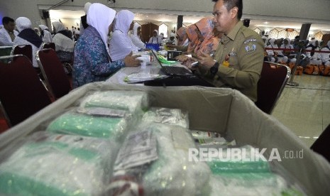 Calon jamaah haji kloter satu melakukan cek kesehatan sebelum bersiap untuk berangkat ke tanah suci di Asrama Haji Pondok Gede, Jakarta, Kamis (27/7). 