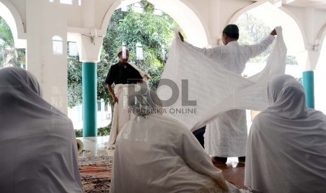 Calon Jamaah Haji sedang dianjarkan cara pemakaian kain ikhram di Asrama Haji Pondok Gede, Jakarta, Rabu (25/2).