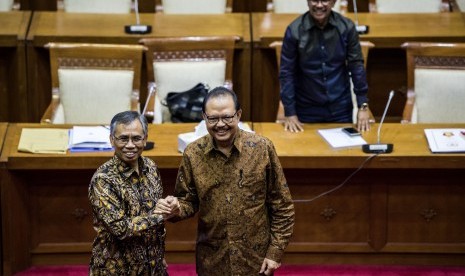 Calon Ketua Otoritas Jasa Keuangan (OJK) Wimboh Santoso (kiri) dan Sigit Pramono (kedua kiri) berjabat tangan di sela-sela uji kepatutan dan kelayakan calon Ketua Dewan Komisioner Otoritas Jasa Keuangan (OJK) di Komisi XI DPR, Kompleks Parlemen, Senayan, Jakarta, Senin (5/6).