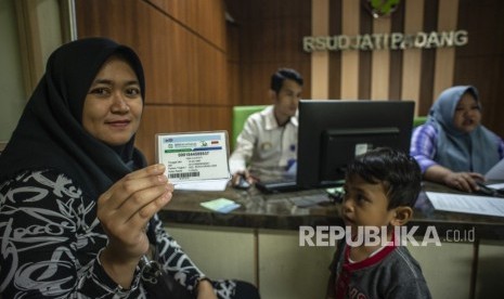 Calon pasien menunjukkan kartu BPJS Kesehatan saat menyelesaikan proses administrasi di RSUD Jati Padang, Jakarta, Senin (7/1/2019). 