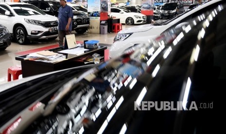 Calon pembeli berjalan melintasi deretan mobil bekas yang dijual di bursa mobil bekas, WTC Mangga Dua, Jakarta, Jumat (9/8/2019).