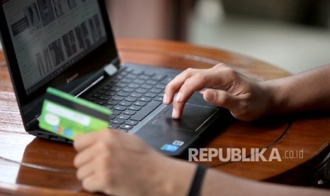 Calon pembeli melihat koleksi fashion terbaru mealui salah satu gerai E-Commerce melalui telfon genggamnya di Jakarta, Senin (31/7).