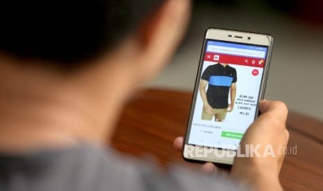 Calon pembeli melihat koleksi fashion terbaru mealui salah satu gerai e-commerce melalui telepon genggamnya. ilustrasi