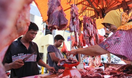 Calon pembeli menimbang daging sapi di pasar tradisional (ilustrasi).