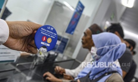 Calon pengguna transportasi Moda Raya Terpadu (MRT) menunjukan pin prioritas di Stasiun MRT Jakarta, Jumat (10/1/2020).