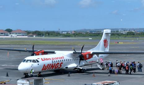 Calon penumpang antre menaiki pesawat udara di Bandara Internasional I Gusti Ngurah Rai, Badung, Bali, Ahad (14/8/2022). Pemerintah resmi menurunkan harga tiket pesawat.