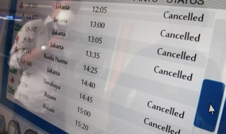 Calon penumpang berada di depan layar informasi jadwal penerbangan yang memperlihatkan sejumlah penerbangan dibatalkan di Bandara Sultan Syarif Kasim II Pekanbaru, di Pekanbaru, Riau, Selasa (6/10). 