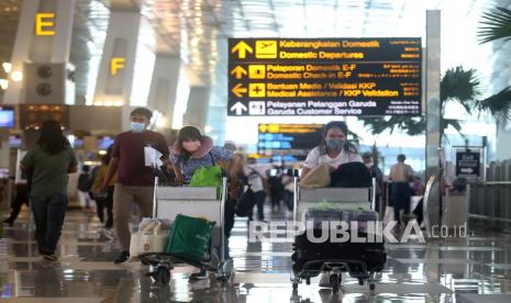 Calon penumpang berjalan di selasar terminal untuk lapor diri di Terminal 3 Bandara Soekarno Hatta, Tangerang, Banten, Rabu (29/12/2021). Pemerintah melarang warga negara Indonesia (WNI) bepergian keluar negeri sementara waktu untuk mengantisipasi penyebaran COVID-19 varian Omicron. 