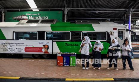 Calon penumpang kereta api beraktivitas di samping kereta inspeksi yang dipasang iklan sosialisasi pencegahan penyebaran virus corona (Covid-19) di Stasiun Bandung, Kota Bandung, Kamis (5/3).