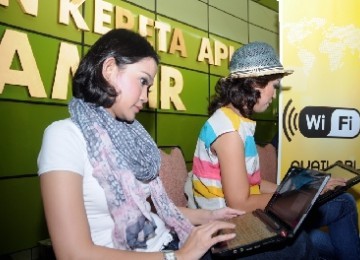 Calon penumpang kereta eksekutif berinternet ria menggunakan fasilitas wi-fi di Stasiun Gambir, Jakarta.