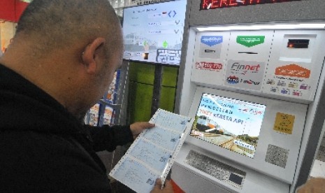 Calon penumpang melakukan pembelian dan pencetakan tiket di mesin e-kiosk di Stasiun Gambir, Jakarta, Senin (13/4).