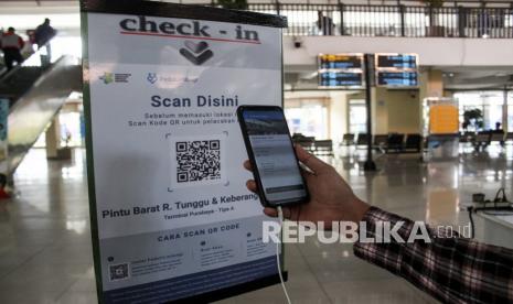 Calon penumpang melakukan scan QR code melalui aplikasi PeduliLindungi di Terminal Purabaya, Bungurasih, Sidoarjo, Jawa Timur, Sabtu (11/9/2021). Penggunaan aplikasi PeduliLindungi sebagai sarat masuk terminal dan untuk mendukung penerapan Surat Edaran Menteri Kesehatan tentang Digitalisasi dokumen kesehatan bagi pengguna transportasi yang terintegrasi dengan aplikasi tersebut. 