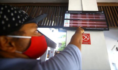 Calon penumpang melihat jadwal penerbangan yang dibatalkan dampak sebaran abu vulkanik Gunung Raung di Bandara Banyuwangi, Jawa Timur, Ahad (7/2/2021). PT Angkasa Pura II kantor cabang Banyuwangi mengonfirmasikan penutupan bandara karena adanya sebaran abu vulkanik Gunung Raung yang dinilai berisiko bagi penerbangan.