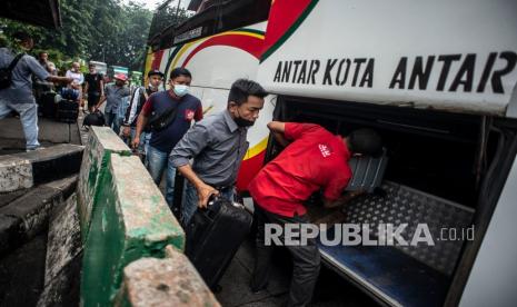 Calon penumpang memasukkan barang bawaan ke dalam bagasi bus di Terminal Bus Antarkota Antarprovinsi (AKAP) Kampung Rambutan, Jakarta, Selasa (21/12). Kementerian Perhubungan (Kemenhub) mencatat pergerakan penumpang moda transportasi jalan pada hari libur Natal atau Sabtu (25/12) meningkat. 