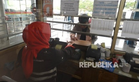 Calon penumpang membeli tiket sebelum memasuki kapal di Pelabuhan Merak, Banten, Ahad (4/6).