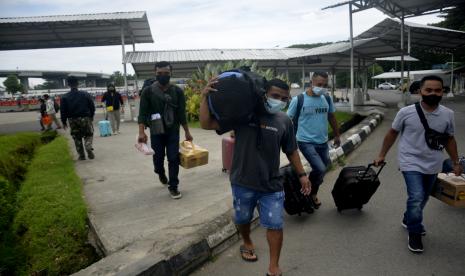 Calon penumpang mengangkat barangnya berjalan menuju ke ruang keberangkatan di Bandara Internasional Sultan Hasanuddin, Kabupaten Maros, Sulawesi Selatan, Rabu (27/4/2022). Target pertama yang harus diselesaikan dari pembangunan proyek Kereta Api (KA) Makassar-Parepare yakni jalur Maris-Barru sepanjang 71 kilometer.