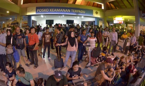 Calon penumpang menunggu jadwal penerbangan saat terjadi kebakaran di kawasan Terminal Keberangkatan Domestik Bandara Internasional I Gusti Ngurah Rai, Bali, Jumat (19/4/2019).