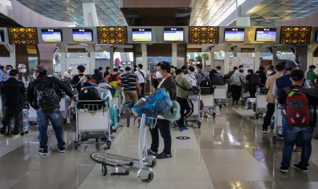 Calon penumpang pesawat antre di area lapor diri sebelum melakukan penerbangan di Terminal 3 Bandara Internasional Soekarno Hatta, Tangerang, Banten, Sabtu (23/10). Kementerian Perhubungan mengeluarkan aturan terbaru terkait syarat penerbangan udara pada masa PPKM yakni penerbangan dari atau ke bandara di pulau Jawa dan Bali wajib menunjukkan surat keterangan negatif RT-PCR yang sampelnya diambil maksimal 2X24 jam sebelum keberangkatan. 