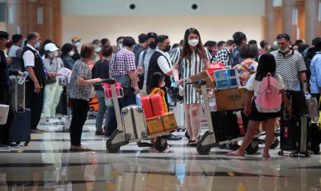 Calon penumpang pesawat antre di area lapor diri sebelum melakukan penerbangan di Bandara Internasional Juanda Surabaya di Sidoarjo, Jawa Timur.. Menteri Koordinator Bidang Kemaritiman dan Investasi Luhut Binsar Pandjaitan menyampaikan, pemerintah akan melakukan penyesuaian regulasi pintu masuk internasional di wilayah Jawa dan Bali.