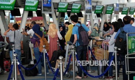 Calon penumpang pesawat antre di depan konter 