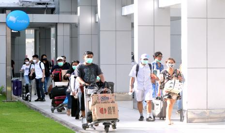 Calon penumpang pesawat udara membawa barang bawaan di Terminal Domestik Bandara Internasional I Gusti Ngurah Rai, Bali. Selama masa libur Natal dan tahun baru 2020 pelaku perjalanan ke Bali dengan pesawat diharuskan menyertai surat keterangan negatif lewat tes PCR. Sedang pelaku perjalanan lewat jalur darat diminta menunjukkan keterangan hasil nonreaktif rapid antigen. 