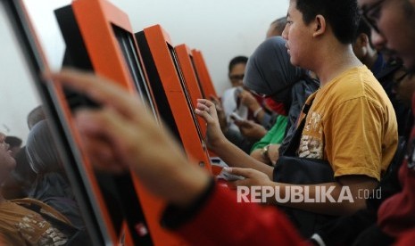 Calon penumpang sedang mengantri saat sedang mencetak tiket kereta di Stasiun Senen, Jakarta, Jumat (1/4). Pembelian tiket untuk mudik Lebaran atau H-90 hari sebelum hari pemberangkatan sudah dapat dibeli namun terdapat beberapa ketentuan, di antaranya set