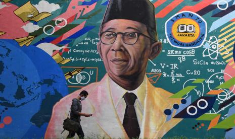 Calon peserta didik melintas di depan mural Bapak Pendidikan Nasional Ki Hajar Dewantara usai melaporkan diri dan verifikasi data pada jalur tahap akhir Penerimaan Peserta Didik Baru (PPDB) di Posko PPDB SMAN 70 Jakarta, Rabu (8/7/2020).